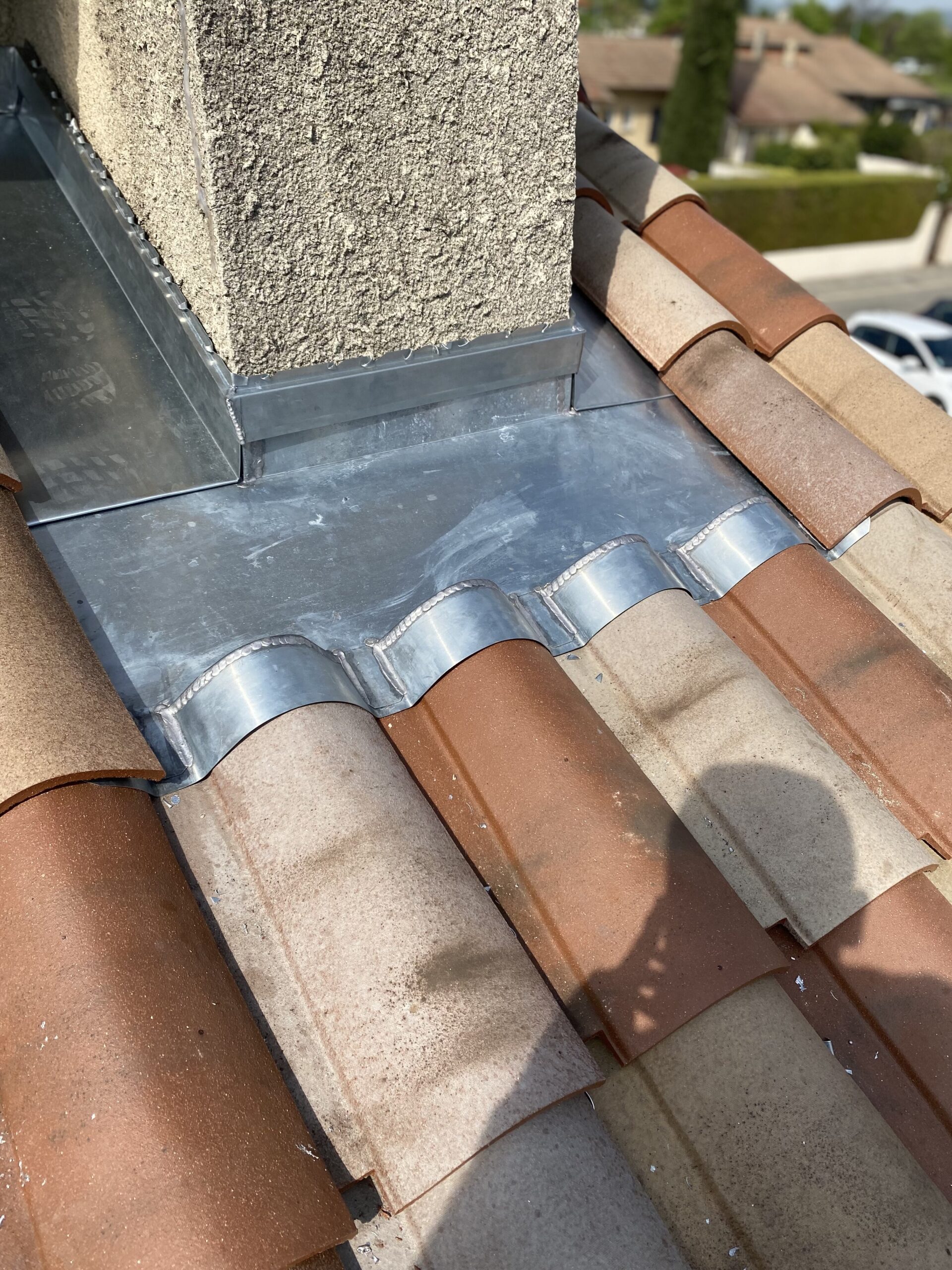 Roof flashing installation on tiled roof for waterproofing and durability.