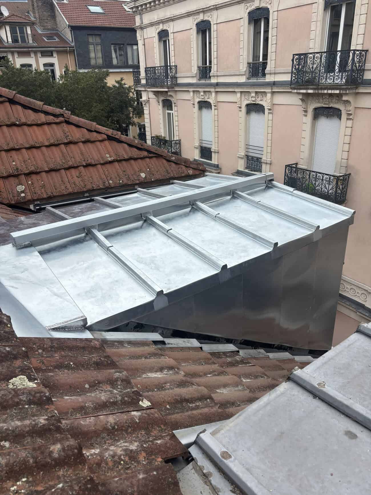 Metal roofing installation on a residential building with detailed construction elements.