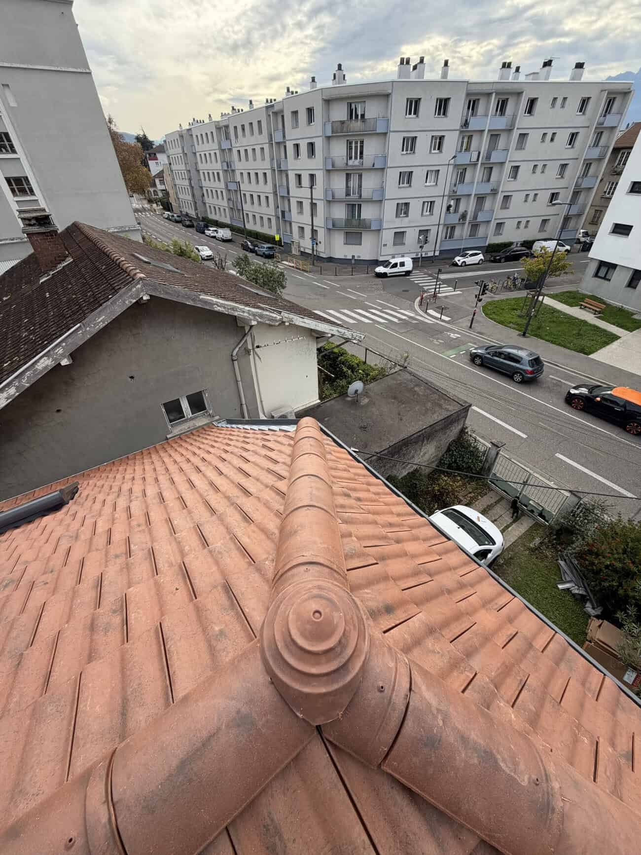 Roof with terracotta tiles and chimney, urban residential area.